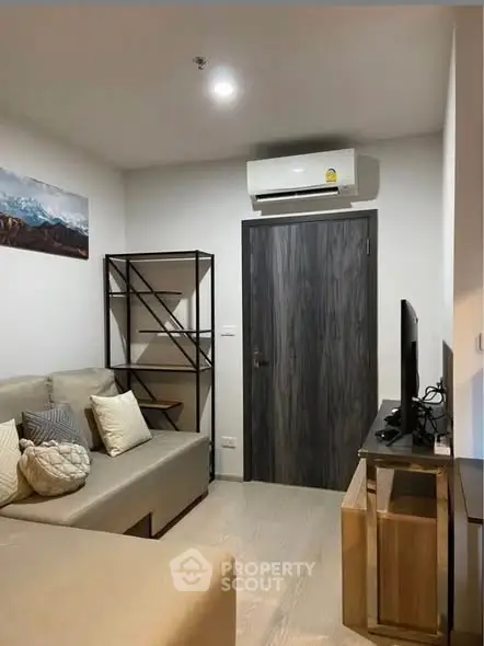 Cozy living room with modern decor and air conditioning, perfect for relaxation.