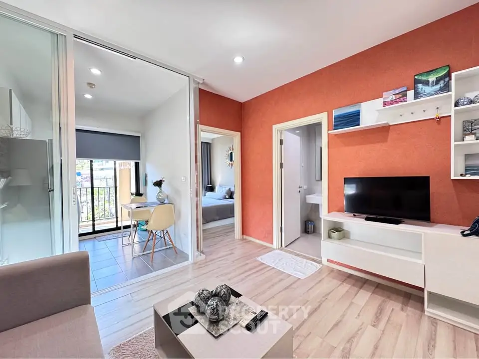 Modern living room with open layout and balcony view, featuring stylish decor and natural light.