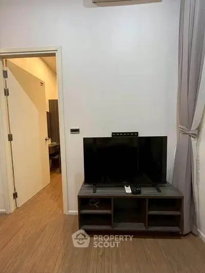 Modern living room with sleek TV stand and wooden flooring, showcasing a minimalist design.