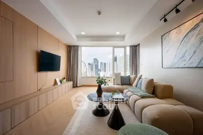 Modern living room with city view, stylish furniture, and natural light.
