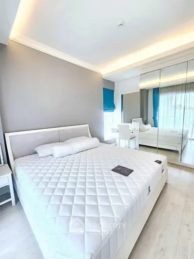 Bright modern bedroom with large bed and mirrored wardrobe