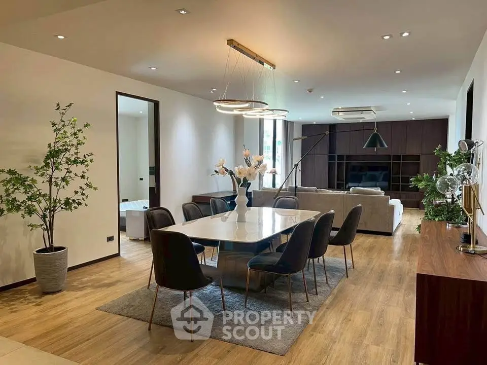 Luxurious open-plan living and dining area with modern decor and elegant lighting.