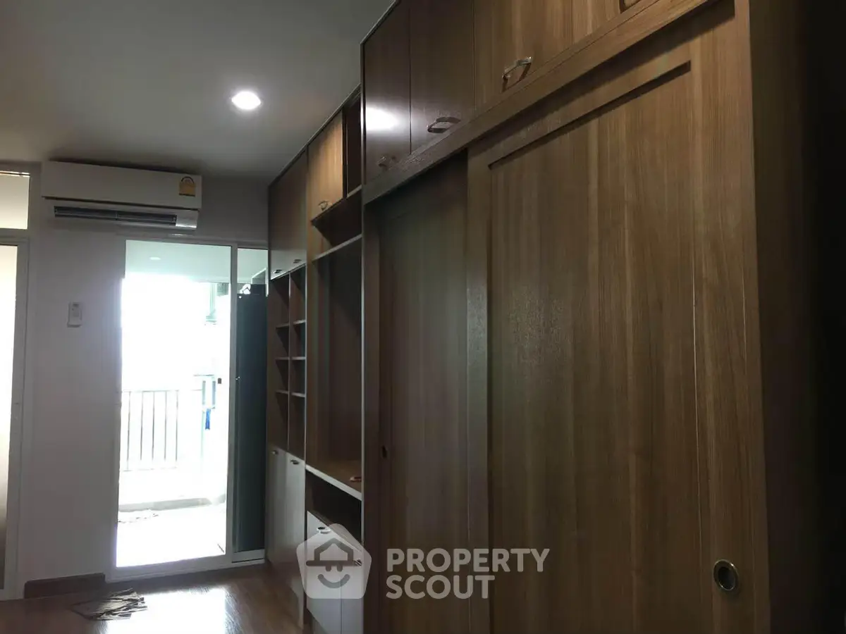 Spacious bedroom with built-in wooden wardrobe and balcony access.