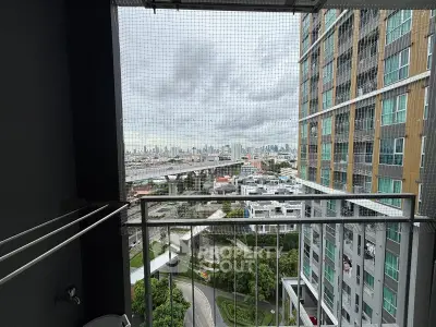 Stunning cityscape view from a high-rise balcony with safety netting, perfect for urban living.
