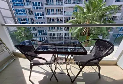 Chic balcony with modern furniture and stunning view of contemporary building and lush greenery.