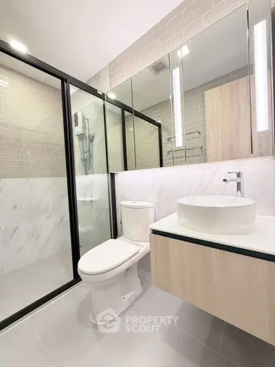Modern bathroom with sleek design, glass shower, and elegant fixtures.