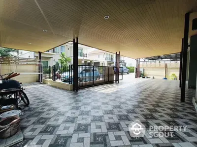 Spacious covered parking area with tiled flooring in modern residential property.