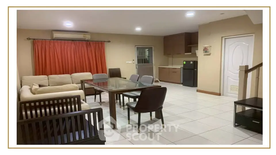 Spacious open-plan living and dining area with modern furniture and kitchen in a cozy apartment.