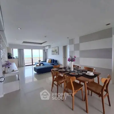 Spacious living and dining area with ocean view, modern furniture, and elegant decor.
