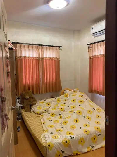 Cozy bedroom with floral bedding and warm lighting, perfect for relaxation.
