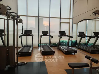 Modern gym with treadmills and city view, perfect for fitness enthusiasts.