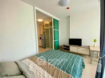 Modern bedroom with sliding glass doors and cozy decor in a stylish apartment.
