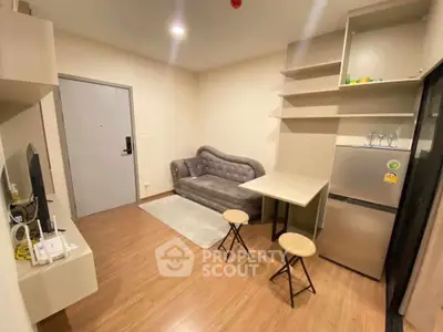Modern living room with stylish sofa and compact kitchen area in cozy apartment.