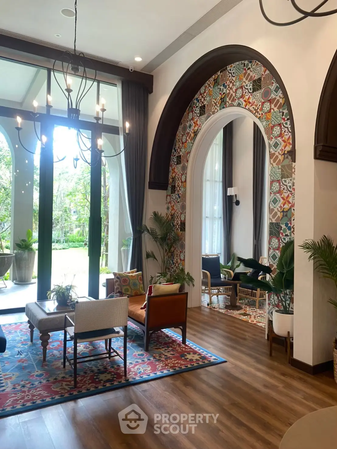 Luxurious living room with elegant decor and large windows overlooking a lush garden.