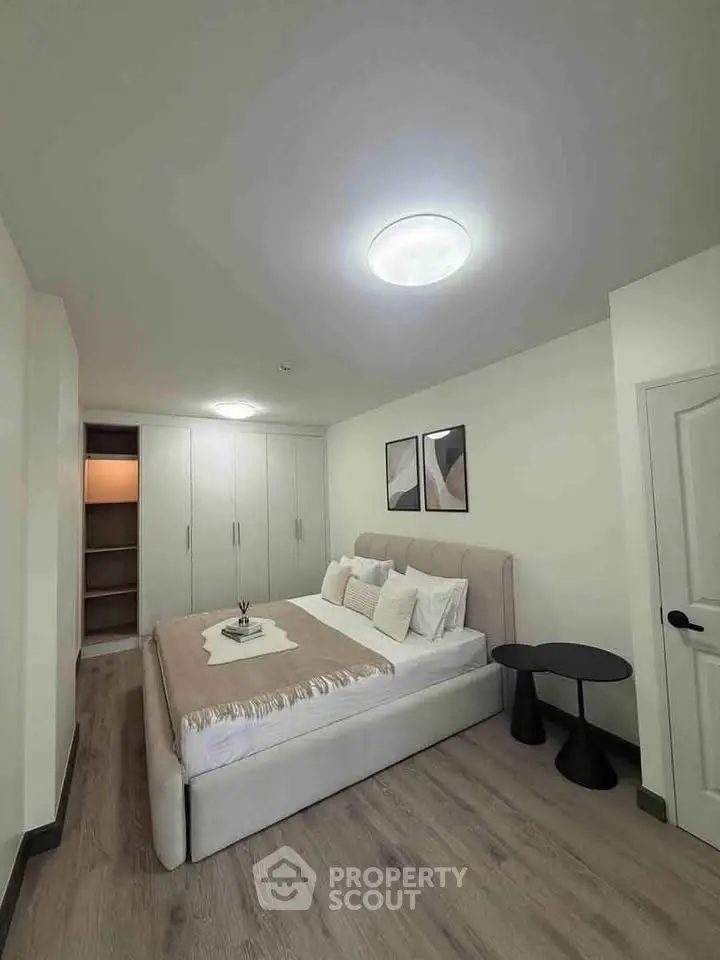 Spacious bedroom with modern decor and ample storage in a stylish real estate property.