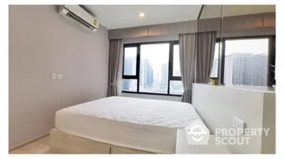 Spacious bedroom with large windows offering ample natural light and a stunning city view, complete with modern air conditioning for optimal comfort.