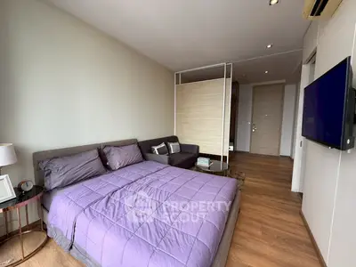 Modern bedroom with stylish decor and wall-mounted TV