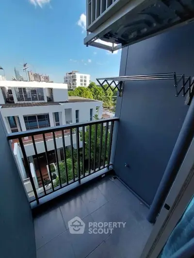 Modern balcony with city view and clothes drying rack, perfect for urban living.