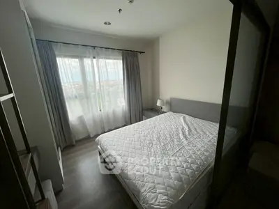 Cozy bedroom with large window and modern decor, perfect for relaxation.