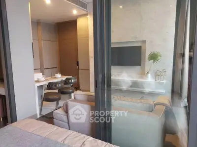 Modern living room with stylish decor and open dining area, featuring sleek furniture and elegant design.