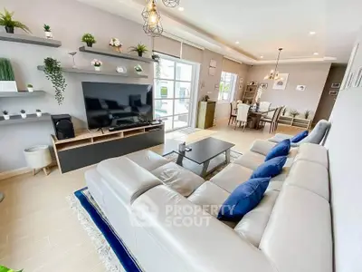 Spacious modern living room with elegant decor and large TV, perfect for family gatherings.