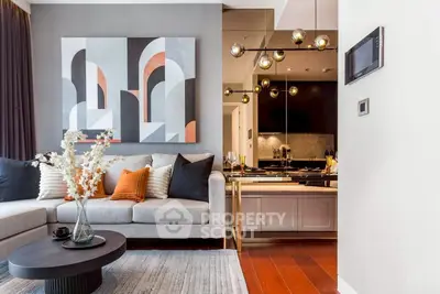Modern living room with stylish decor and open kitchen layout, featuring elegant lighting and contemporary artwork.