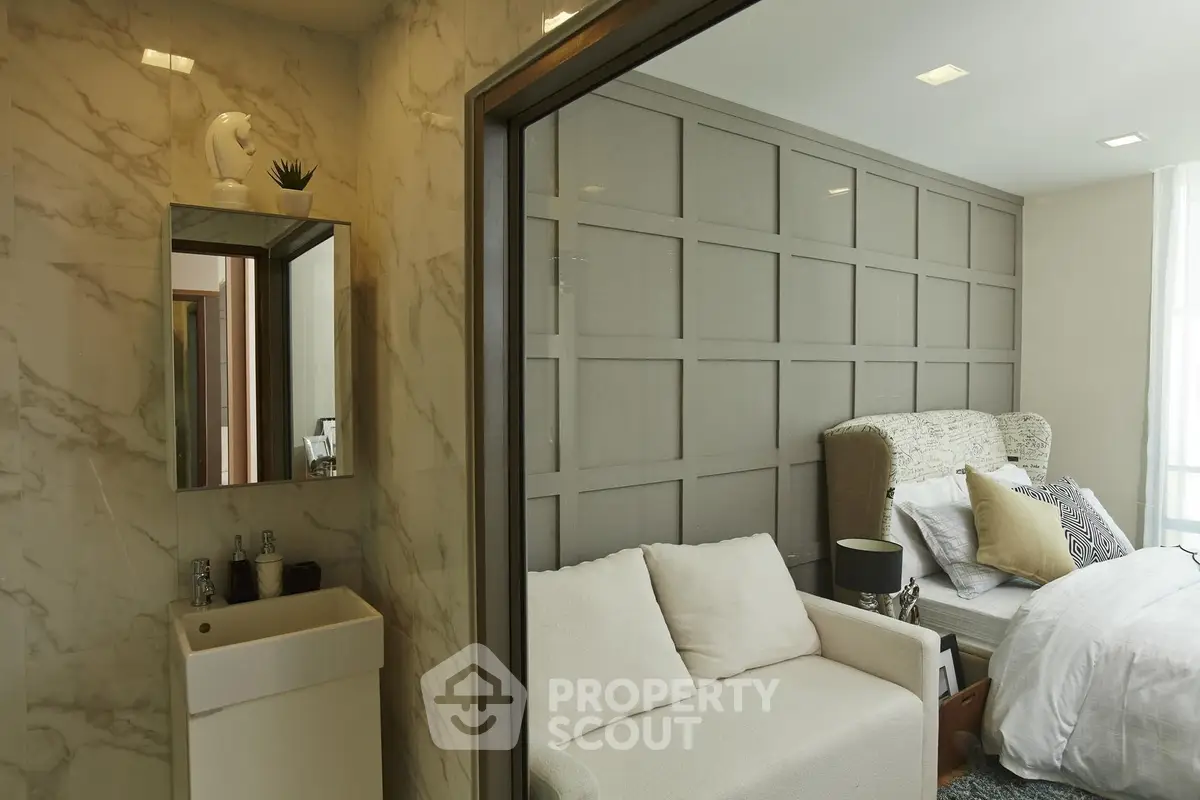 Luxurious bedroom with elegant marble bathroom and cozy seating area