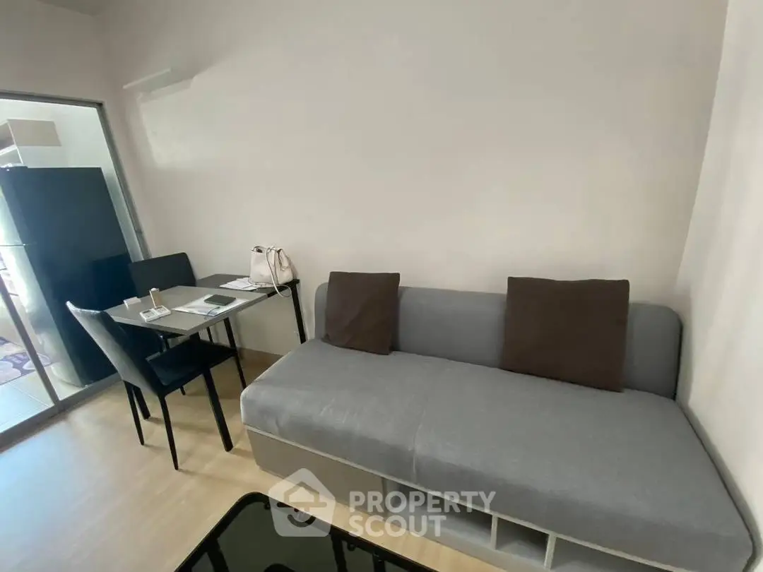 Modern living room with sleek sofa and dining area in a stylish apartment.