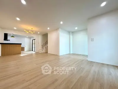 Spacious open-plan living area with modern kitchen and elegant lighting