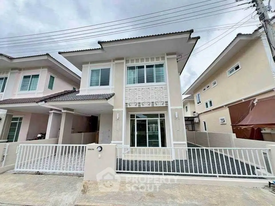 Modern two-story house with stylish facade and gated driveway in suburban neighborhood.
