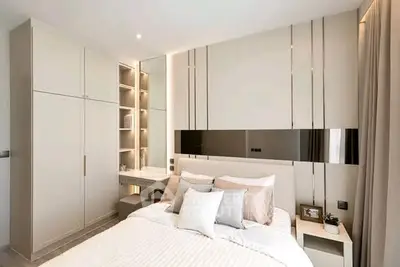 Modern bedroom with sleek design, built-in wardrobe, and cozy ambiance.