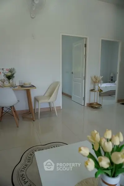 Charming modern interior with dining area and glimpse of a cozy bathroom, perfect for stylish living.