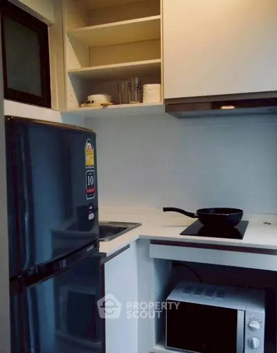 Modern kitchen with sleek appliances and open shelving, perfect for urban living.