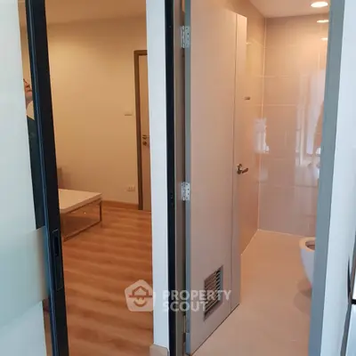 Modern apartment interior with wooden flooring and sleek bathroom design.