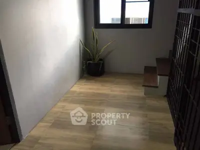 Minimalist interior with wooden flooring and potted plant near staircase