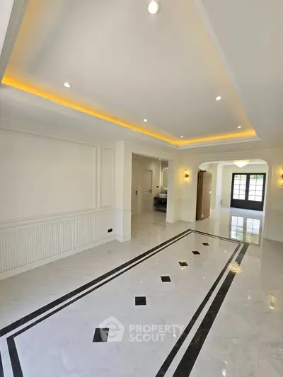 Spacious and elegant living room with modern lighting and marble flooring