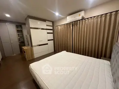Spacious bedroom with modern furnishings and ample storage in a stylish apartment.