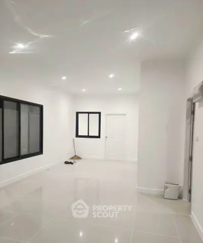 Spacious modern interior with sleek tile flooring and recessed lighting, ideal for customization.