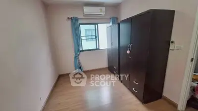 Spacious bedroom with wooden flooring and large wardrobe, perfect for modern living.