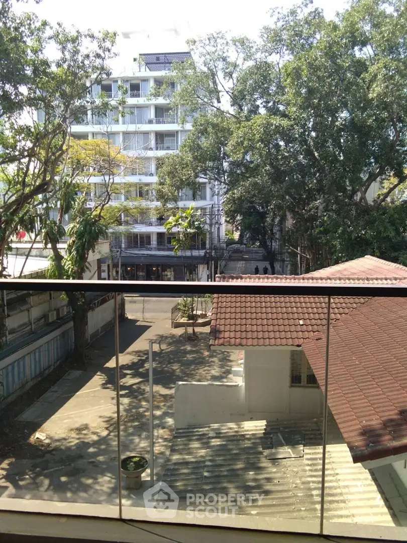 Scenic view from balcony overlooking modern building and lush trees
