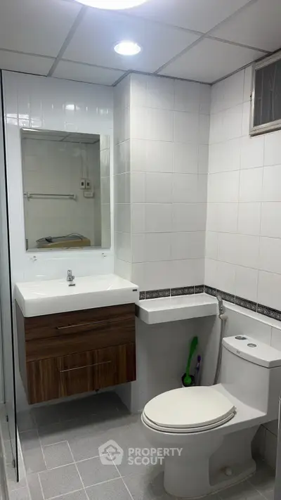 Modern bathroom with sleek fixtures and elegant tile design, featuring a stylish vanity and contemporary toilet.