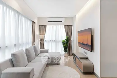 Modern living room with sleek furniture and large windows offering natural light.