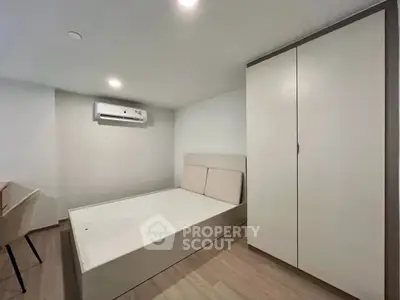 Modern minimalist bedroom with sleek furniture and air conditioning unit