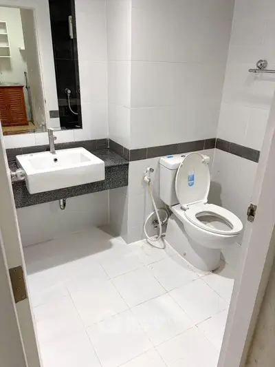 Modern bathroom with sleek white tiles and contemporary fixtures in a stylish apartment.