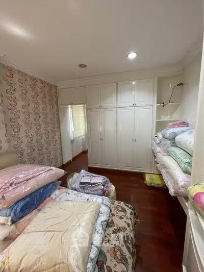 Cozy bedroom with ample storage and stylish wallpaper, perfect for a comfortable living experience.