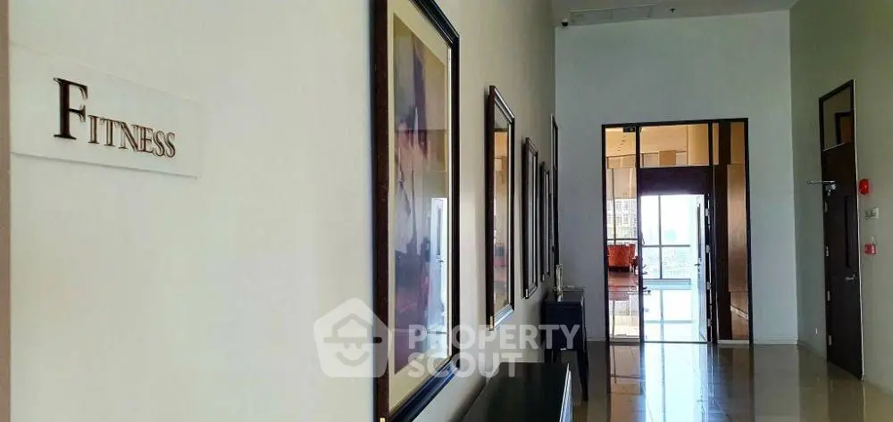 Modern fitness center entrance with sleek design and framed artwork, inviting ambiance for a healthy lifestyle.