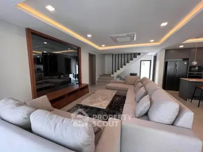 Spacious modern living room with elegant staircase and open kitchen layout
