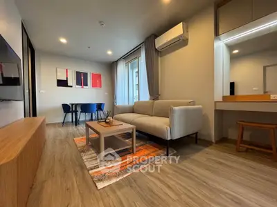 Modern living room with stylish decor and natural light, featuring a cozy sofa and dining area.