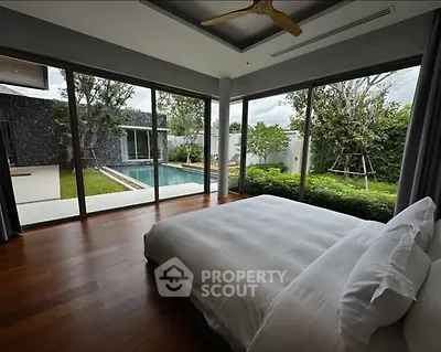 Luxurious bedroom with pool view and floor-to-ceiling windows in modern home