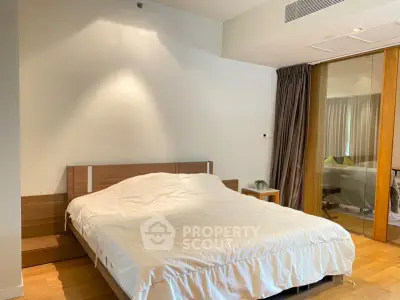 Spacious bedroom with modern design and wooden accents in a luxury apartment.